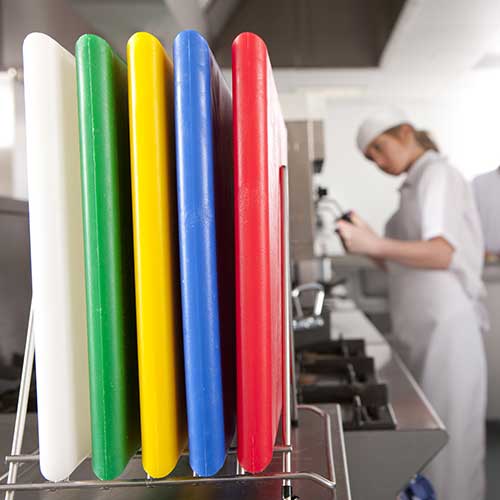 Planches à découper de couleurs différentes sur présentoir dans une cuisine