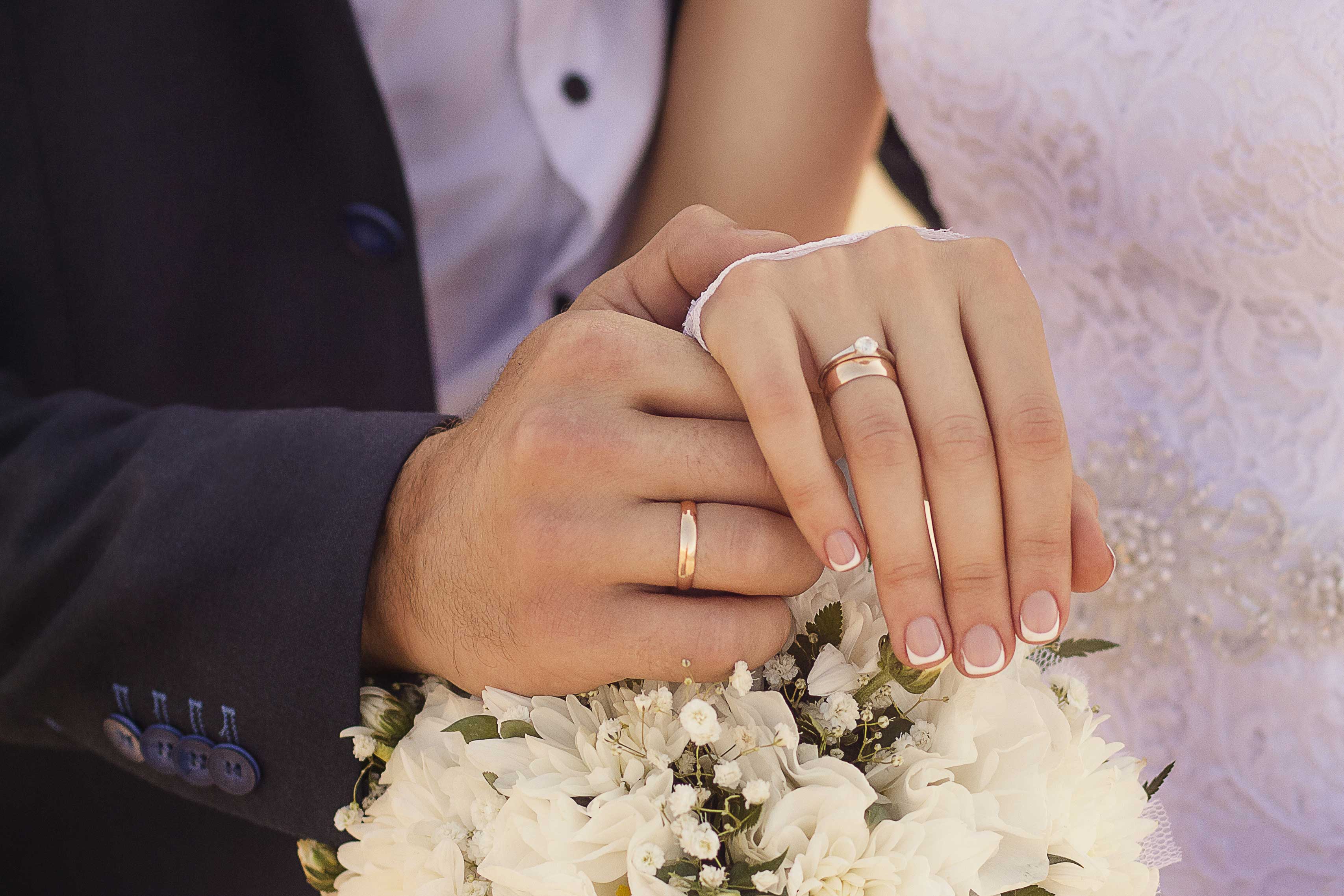 zoom sur la main de jeunes mariés avec leurs anneaux de mariage